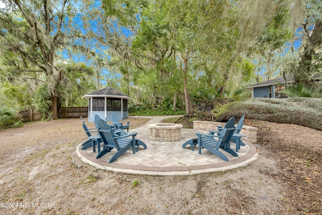 view of yard with an outdoor fire pit, a patio, and a sunroom