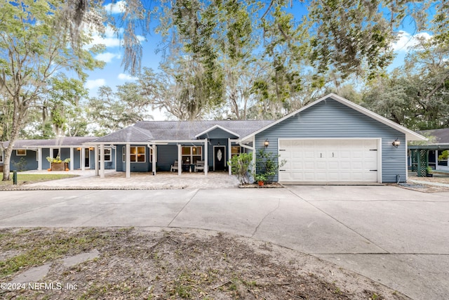 ranch-style house featuring covered porch and a garage