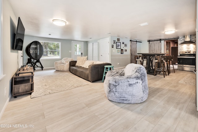 living room featuring light hardwood / wood-style floors and a barn door