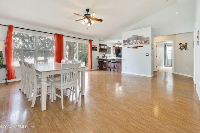 dining space featuring ceiling fan, lofted ceiling, and light wood-type flooring