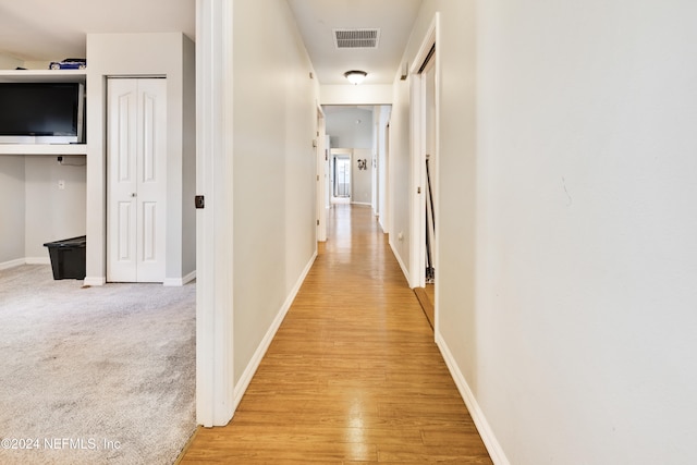 corridor with light hardwood / wood-style flooring