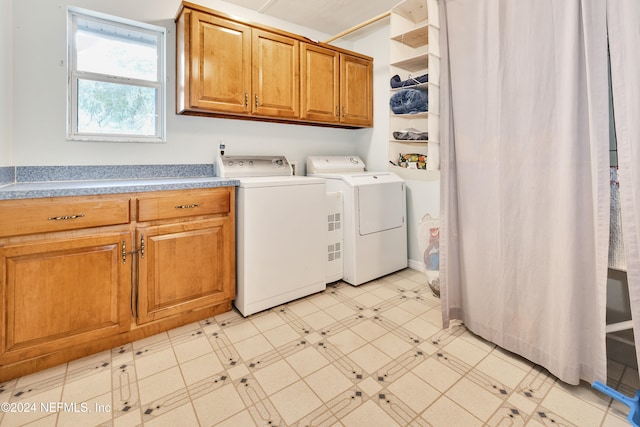 washroom with cabinets and washing machine and clothes dryer