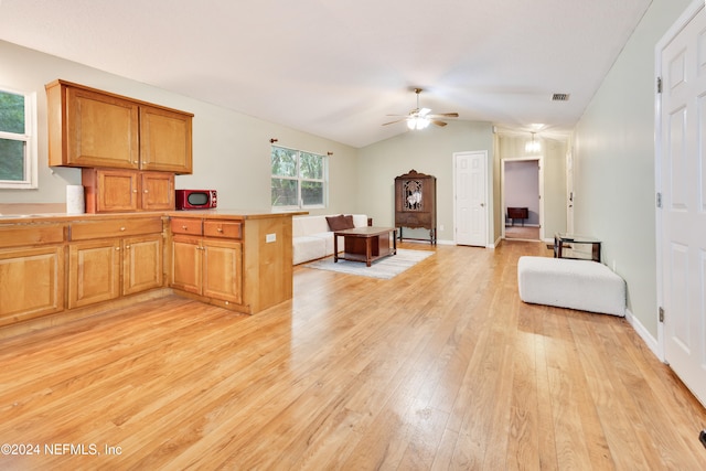 kitchen with kitchen peninsula, lofted ceiling, light wood-type flooring, and ceiling fan