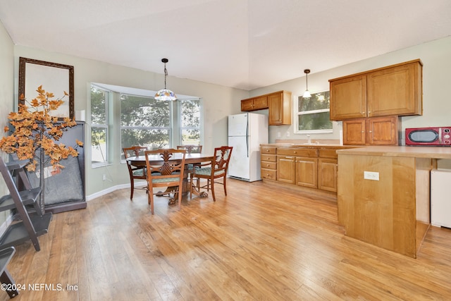 dining space with sink and light wood-type flooring