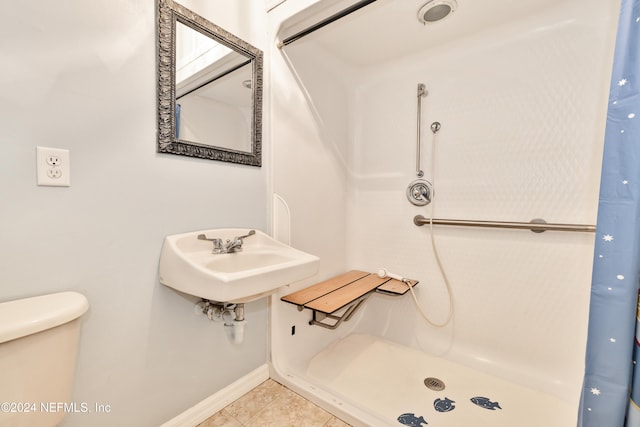 bathroom featuring toilet, sink, tile patterned floors, and a shower with shower curtain