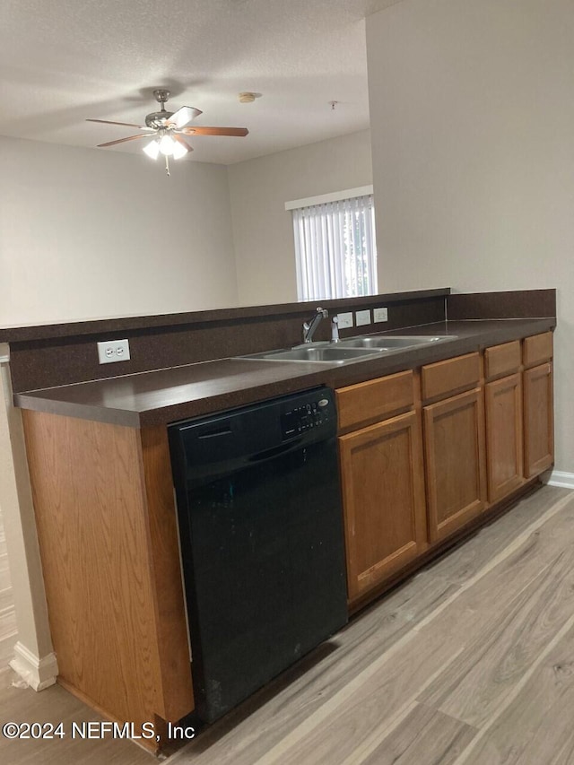 kitchen featuring dishwasher, sink, a textured ceiling, light hardwood / wood-style floors, and ceiling fan