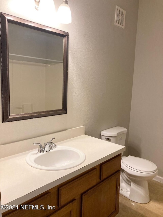 bathroom with vanity, toilet, and tile patterned floors