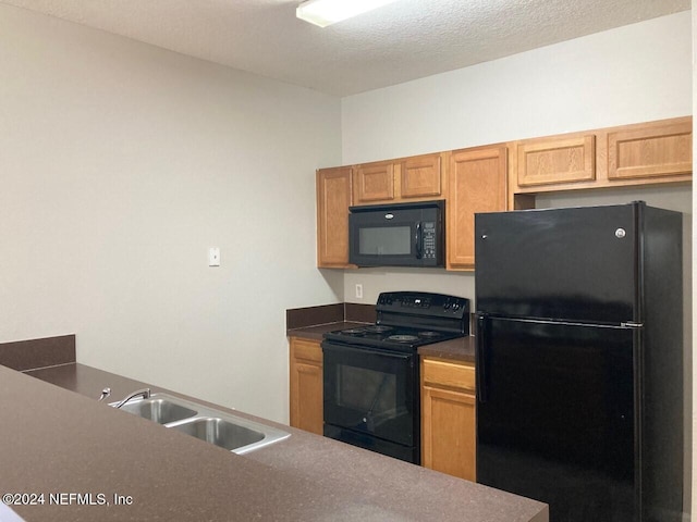 kitchen with sink, black appliances, and a textured ceiling