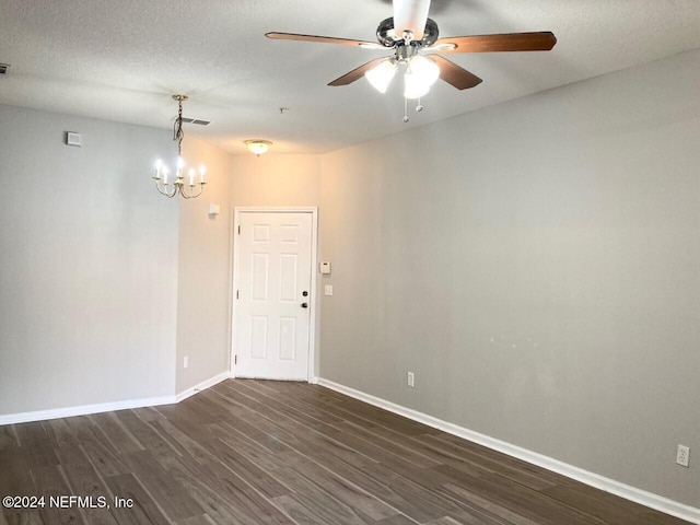 empty room featuring a textured ceiling, dark wood-type flooring, and ceiling fan with notable chandelier