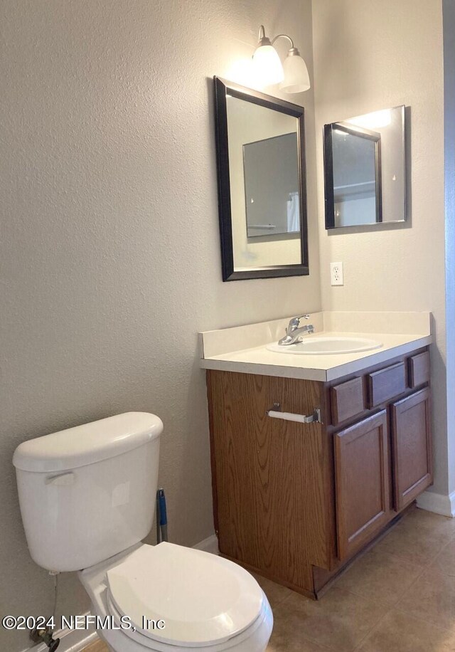 bathroom with vanity, toilet, and tile patterned flooring