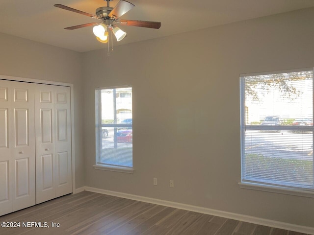 unfurnished bedroom with hardwood / wood-style flooring, a closet, and ceiling fan