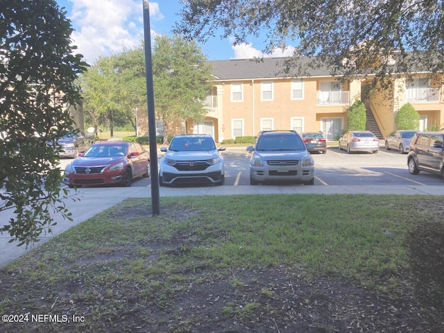 view of parking with a lawn