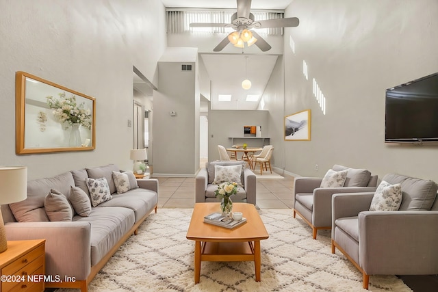 living room featuring ceiling fan, high vaulted ceiling, and light tile patterned floors