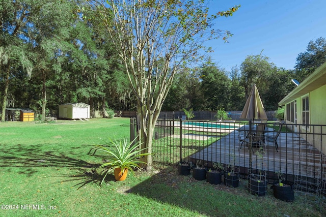 view of yard featuring a fenced in pool, a patio, and a shed