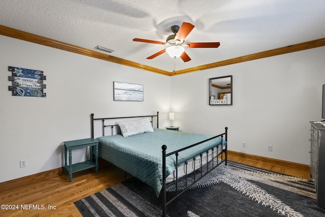 bedroom with hardwood / wood-style flooring, ceiling fan, crown molding, and a textured ceiling