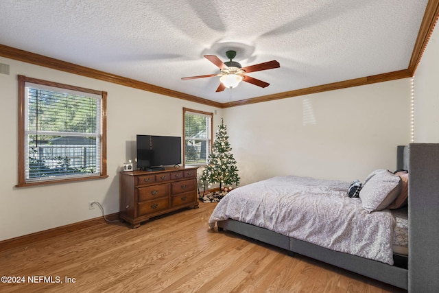 bedroom with multiple windows, ceiling fan, hardwood / wood-style floors, and a textured ceiling