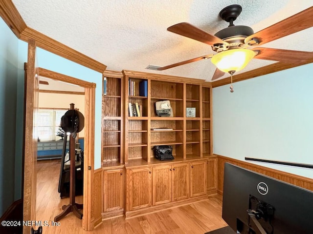 office space featuring a textured ceiling, light wood-type flooring, ceiling fan, and crown molding