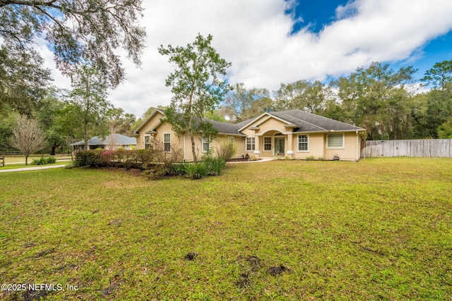 single story home with a front yard and fence