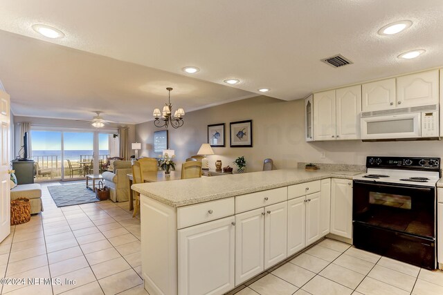 3350 S Fletcher Ave Unit J1, Fernandina Beach, FL 32034 - kitchen with a peninsula, range with electric stovetop, white microwave, visible vents, and light tile patterned floors