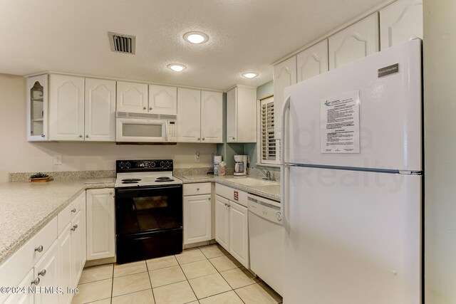 3350 S Fletcher Ave Unit J1, Fernandina Beach, FL 32034 - kitchen with white cabinetry, white appliances, and visible vents