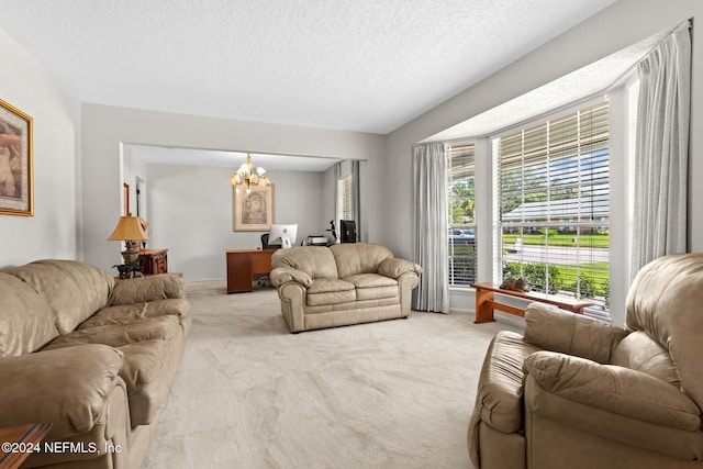 living room featuring light carpet, a textured ceiling, and an inviting chandelier