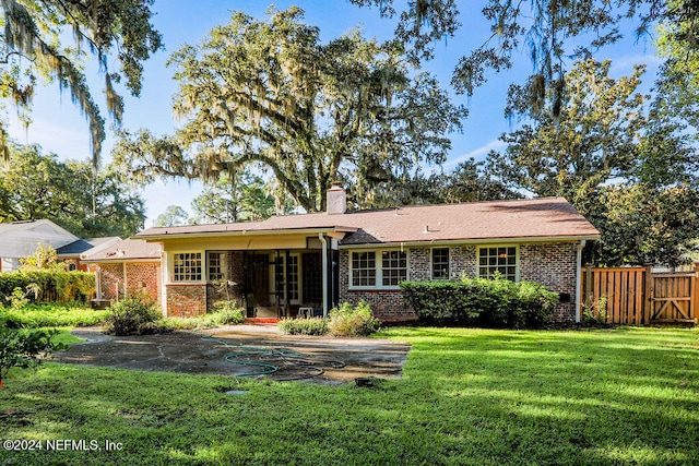 back of house with a patio area and a yard