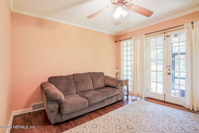 living room with ornamental molding, a healthy amount of sunlight, wood-type flooring, and ceiling fan