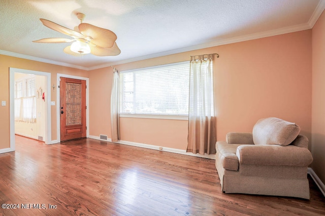 living area featuring crown molding, a textured ceiling, hardwood / wood-style flooring, and ceiling fan