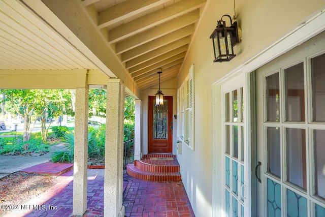 view of exterior entry featuring covered porch