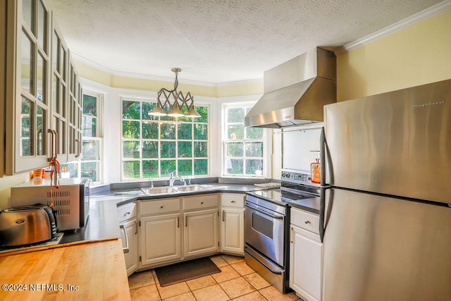 kitchen with appliances with stainless steel finishes, sink, a textured ceiling, white cabinets, and range hood