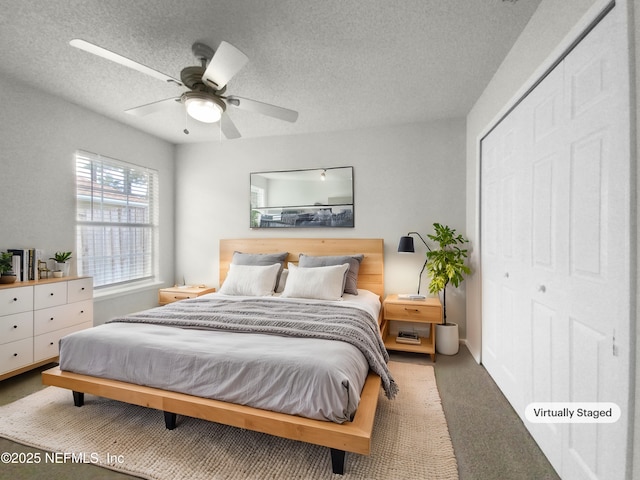 bedroom with ceiling fan, carpet flooring, a textured ceiling, and a closet