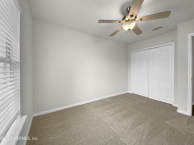 unfurnished bedroom featuring ceiling fan, a closet, and carpet