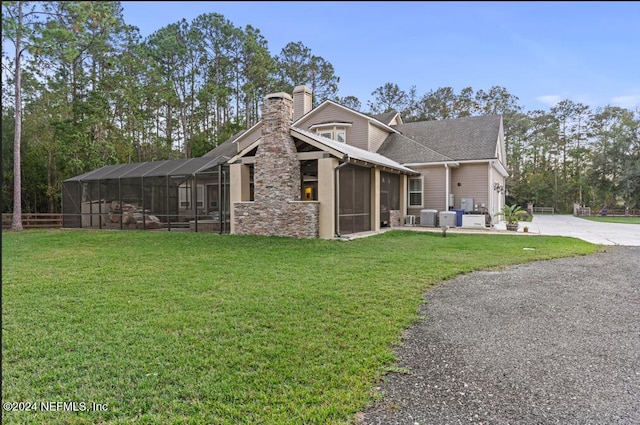 view of front facade featuring cooling unit, a lanai, and a front lawn