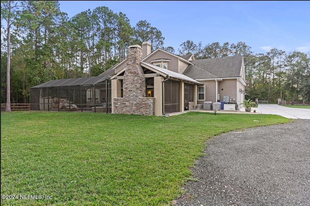 1315 Whispering Pines Rd, Saint Johns, FL 32259 - back of house with a chimney, driveway, a lawn, a lanai, and a shingled roof