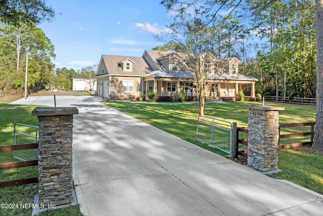 cape cod-style house featuring a front yard and an outbuilding