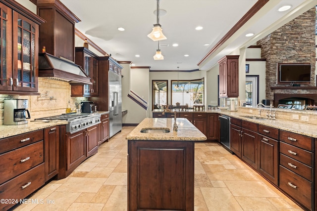 kitchen with sink, decorative light fixtures, a kitchen island with sink, appliances with stainless steel finishes, and ornamental molding