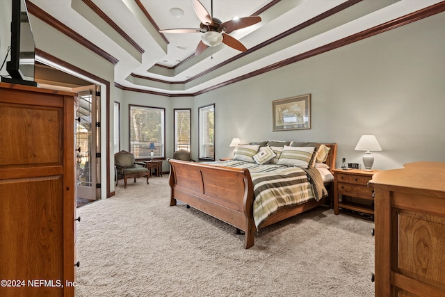 bedroom with a tray ceiling, ceiling fan, crown molding, and light carpet