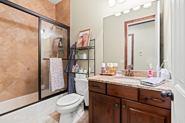 full bathroom with tile patterned floors, vanity, enclosed tub / shower combo, and toilet