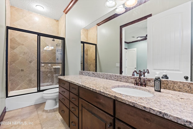 full bathroom featuring vanity, toilet, enclosed tub / shower combo, a textured ceiling, and ornamental molding