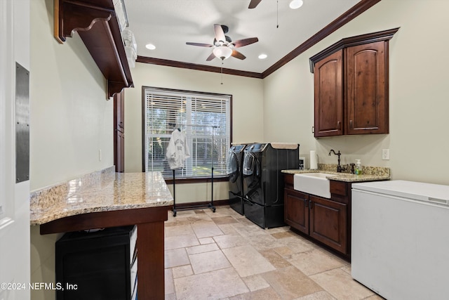 laundry area featuring cabinets, ornamental molding, ceiling fan, sink, and separate washer and dryer