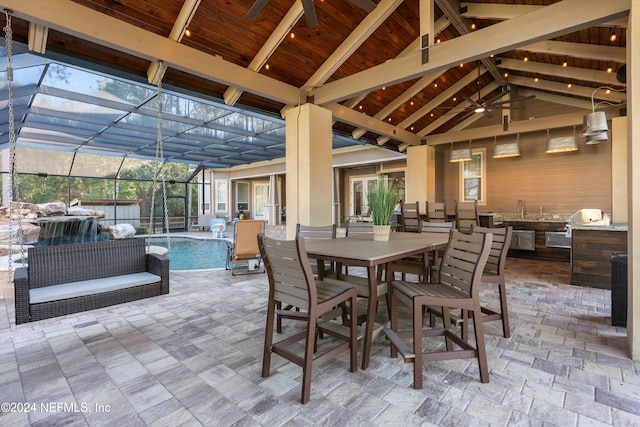 view of patio featuring an outdoor kitchen, ceiling fan, a lanai, and a grill