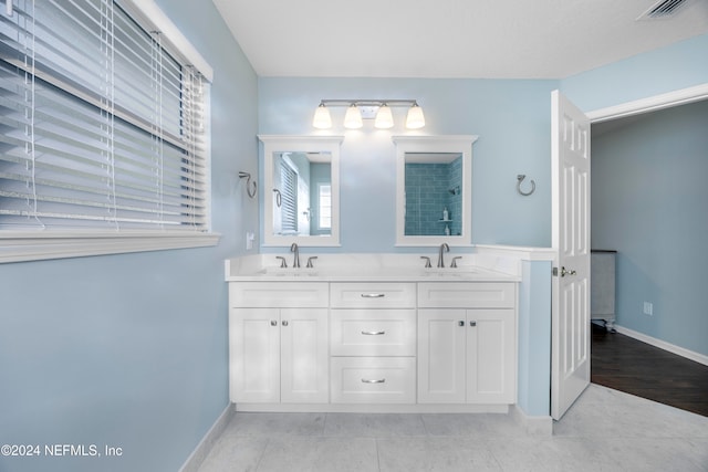 bathroom with a shower, vanity, and tile patterned flooring