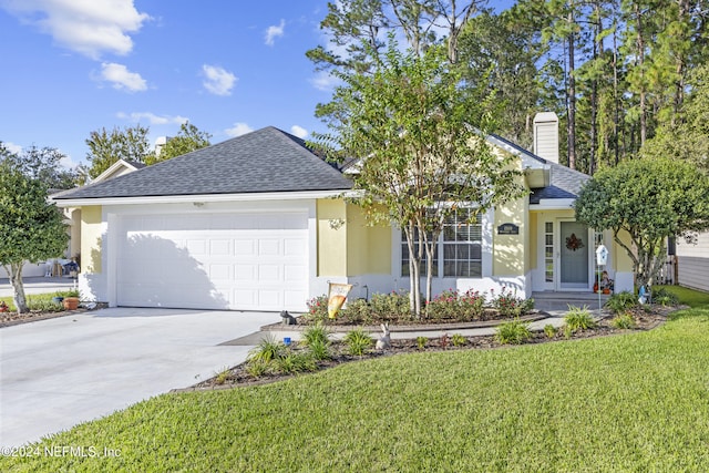 view of front of home with a front yard and a garage