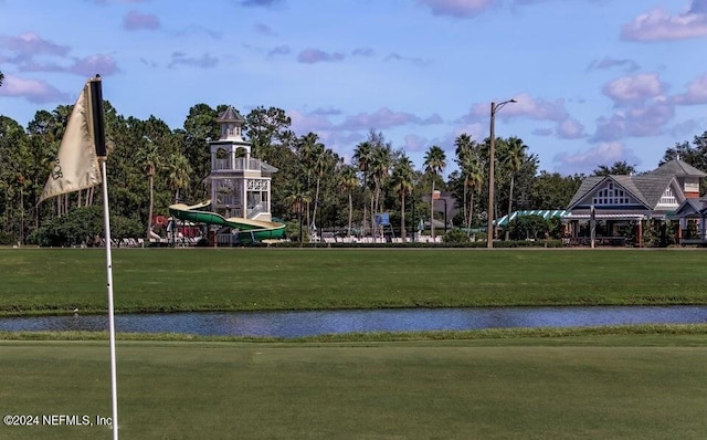 view of property's community with a lawn and a water view