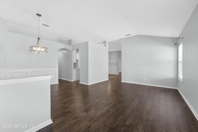 spare room featuring dark wood-type flooring, lofted ceiling, and a chandelier