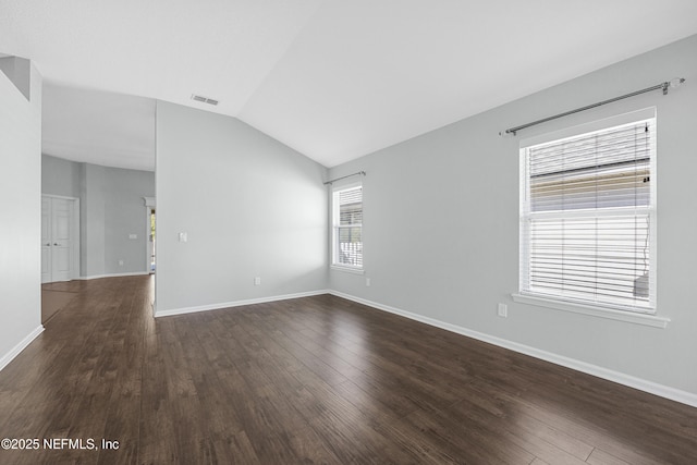 empty room featuring dark hardwood / wood-style flooring and vaulted ceiling