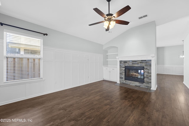 unfurnished living room with lofted ceiling, built in shelves, dark hardwood / wood-style flooring, a fireplace, and ceiling fan