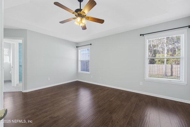 unfurnished room featuring ceiling fan, a wealth of natural light, and dark hardwood / wood-style floors