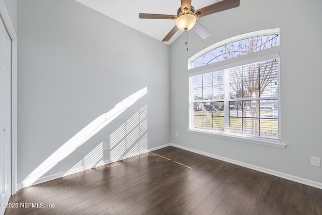 empty room featuring ceiling fan, dark hardwood / wood-style flooring, and vaulted ceiling