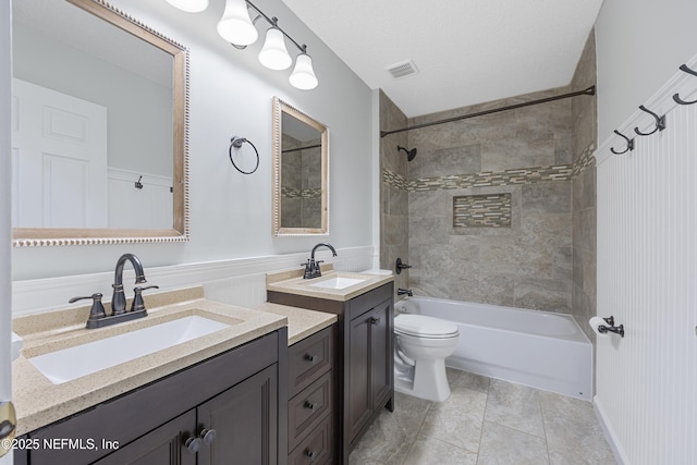 full bathroom with toilet, vanity, tile patterned floors, tiled shower / bath combo, and a textured ceiling